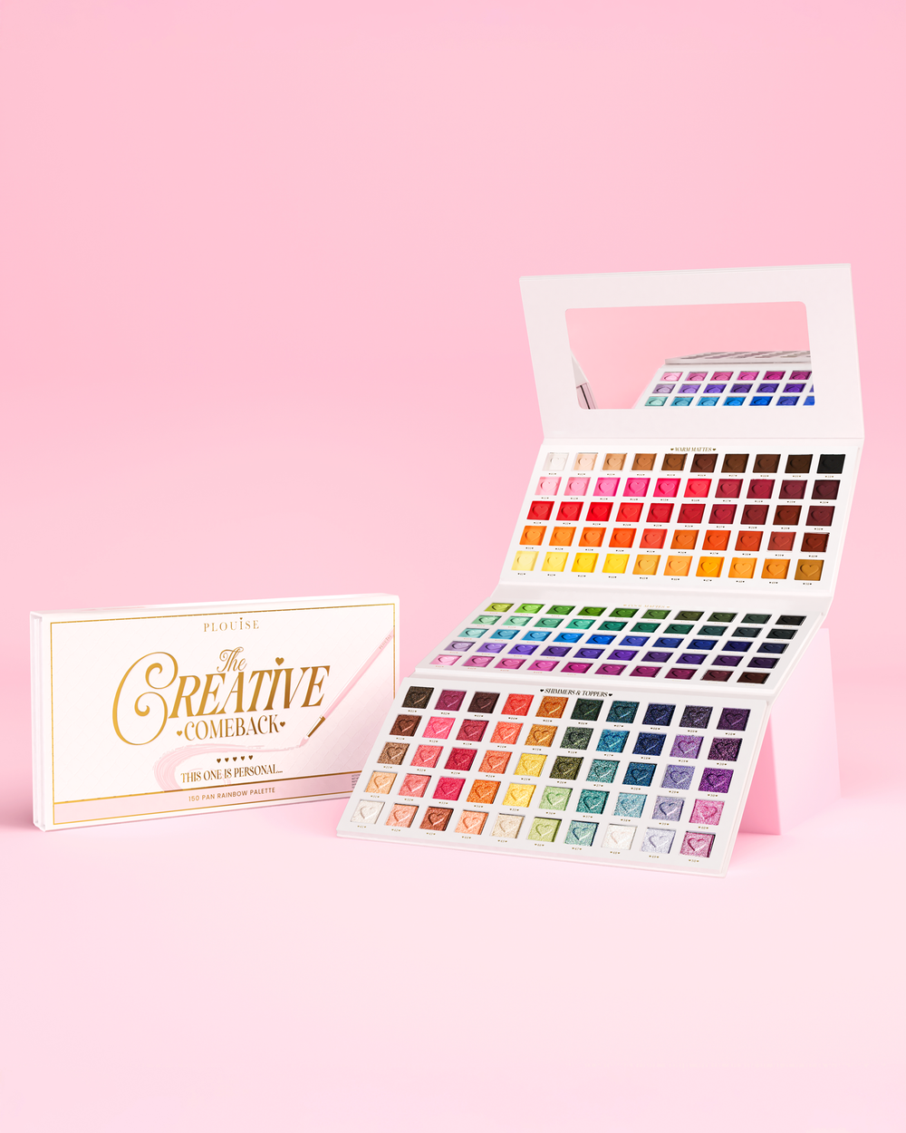 Open het P.Louise Creative Comeback XXXL Rainbow Eyeshadow Palette tegen een roze achtergrond met de roze verpakking ernaast