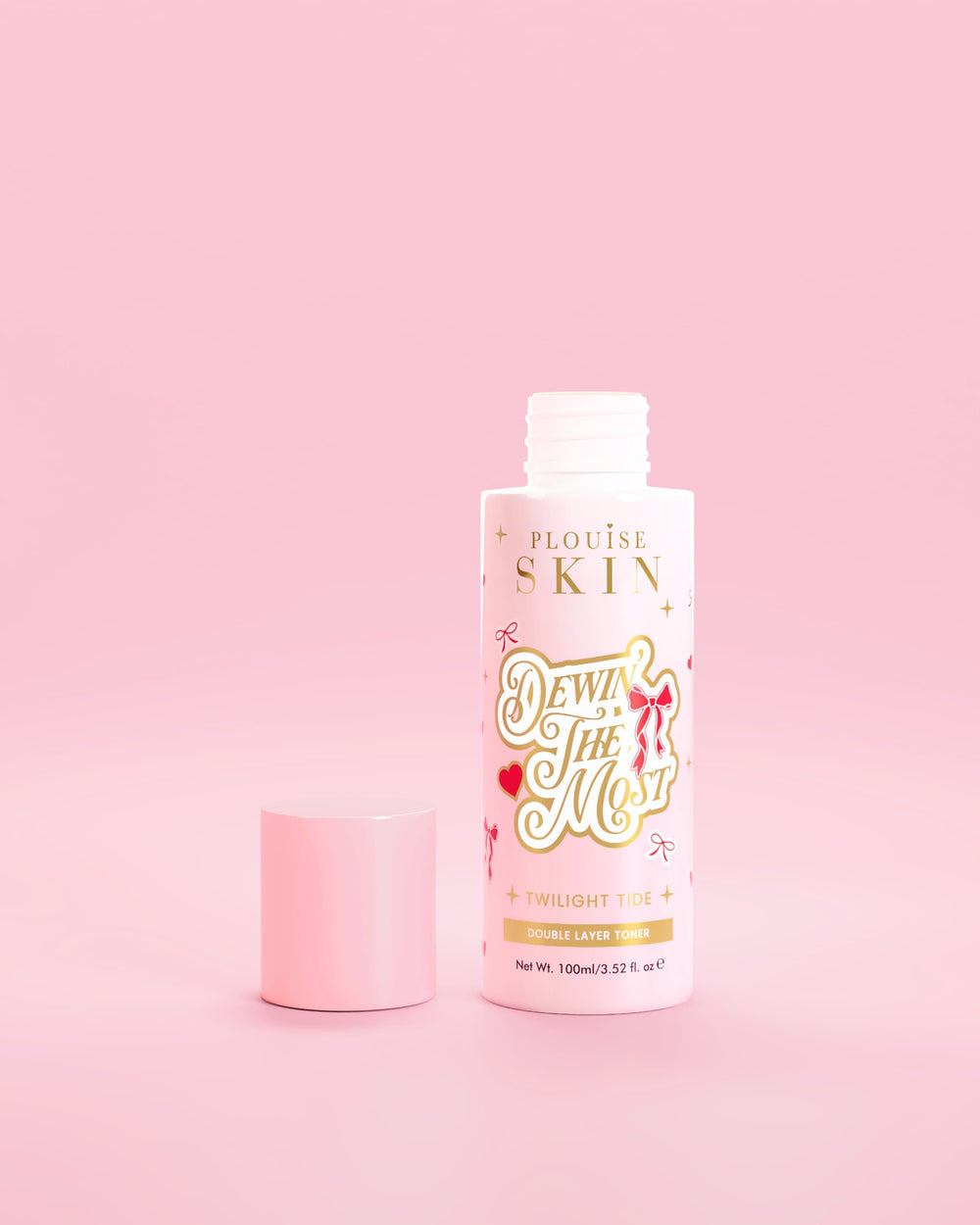 Rosa flaske P.Louise Dewin The MOst Double Layer Toner med rød sløyfedesign mot en rosa bakgrunn