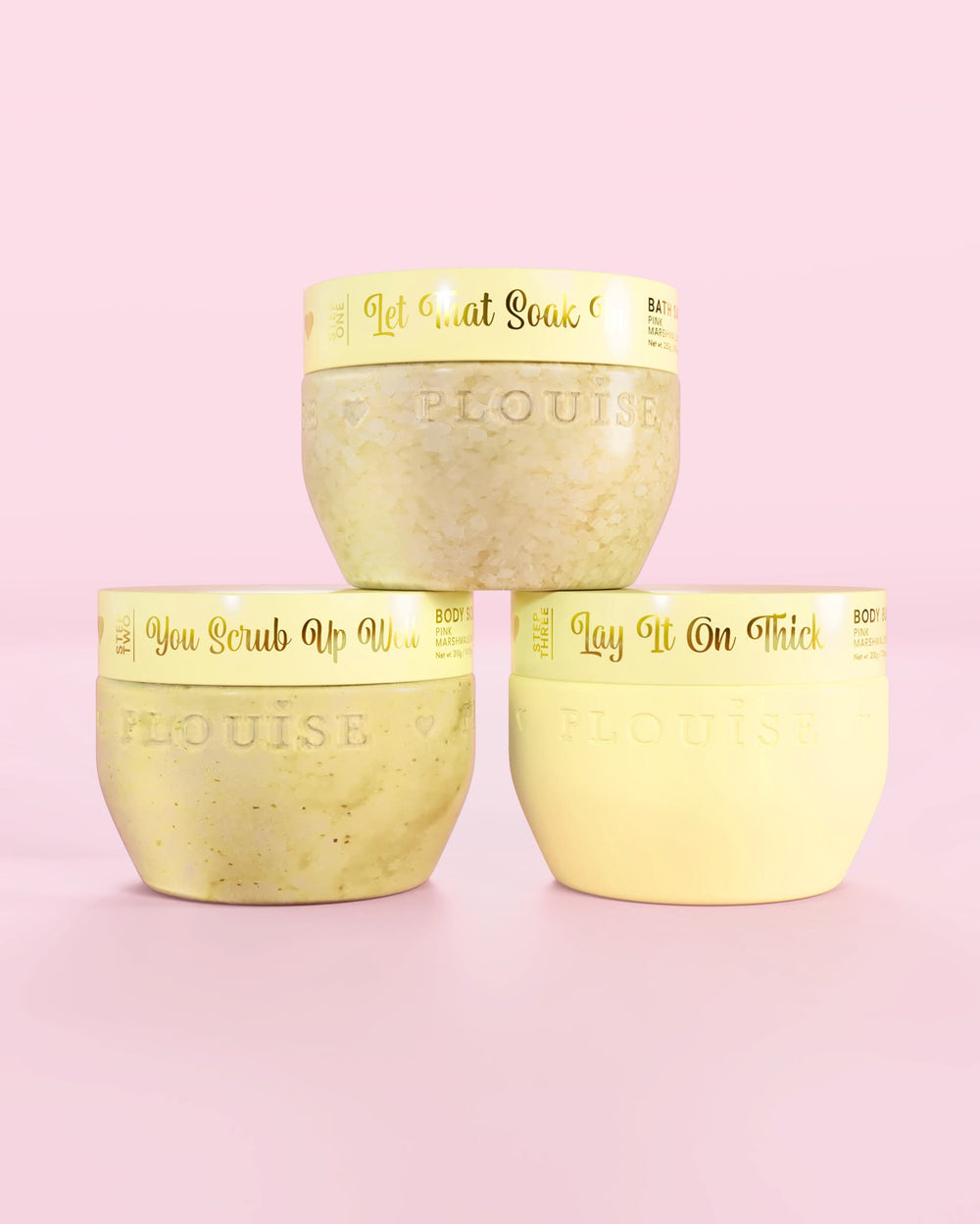 Tre P.Louise Hop Into Self-Care Starwberry Shortcake gula behållare med badsalt, kroppsskrubb och kroppssmör med guldtext på rosa bakgrund