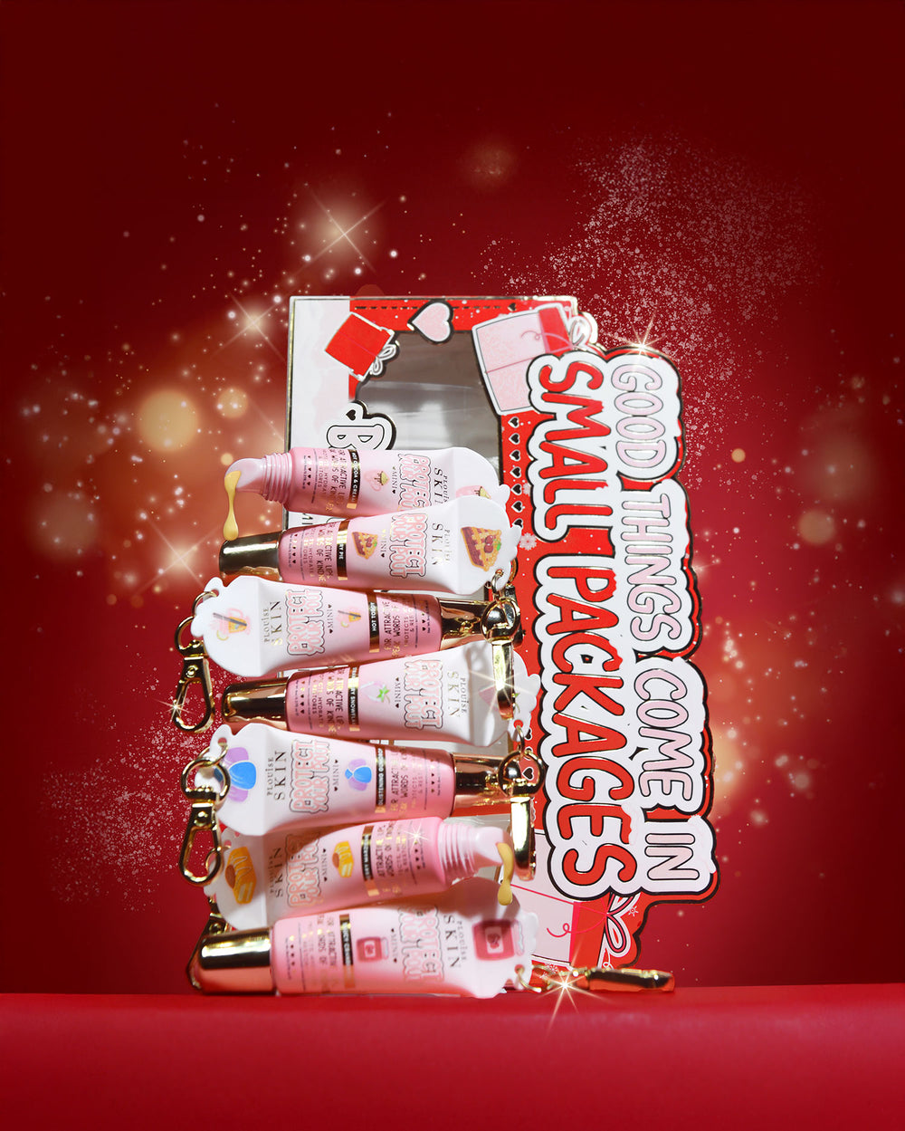 Mini-Lippenpflege-Geschenkset „All Good Things Come In Small Packages“ auf rotem Hintergrund