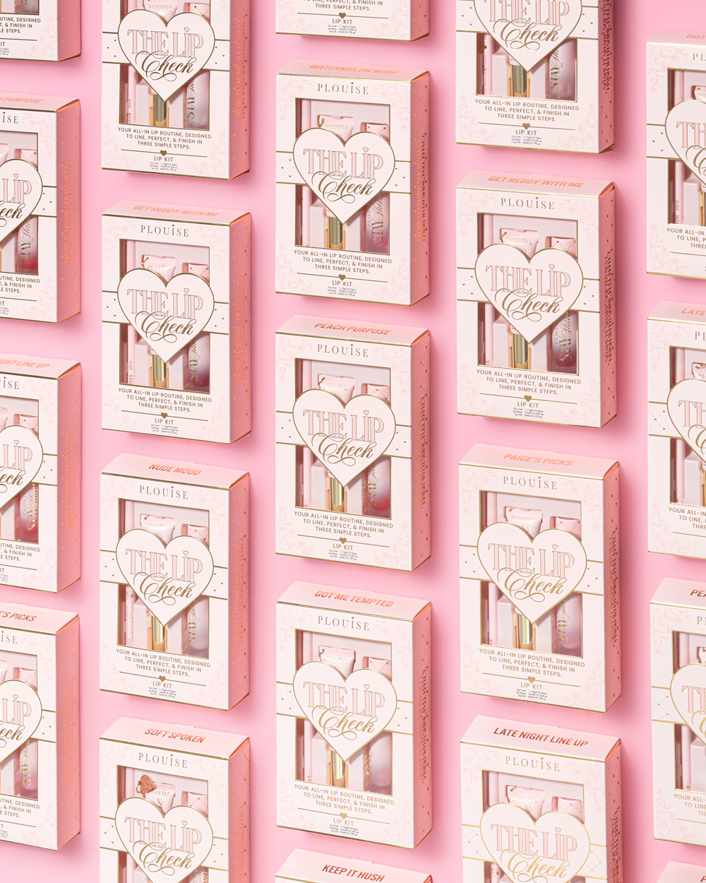 Un motif répétitif de kits pour les lèvres P.Louise 'The Lip Check' roses et blancs disposés en grille sur un fond rose uni.
