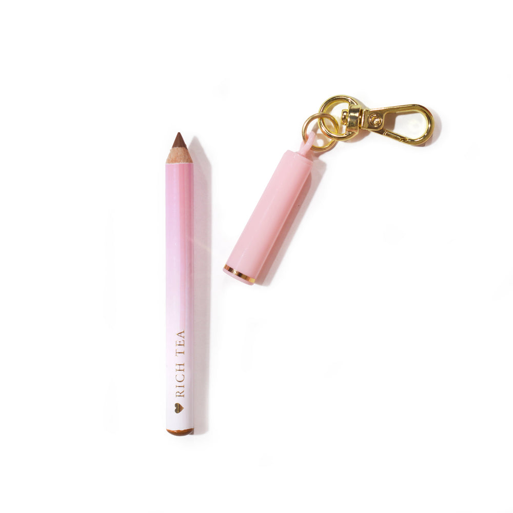 Mini delineador labial rosa P.Louise com chaveiro 'Rich Teal' em um fundo rosa claro