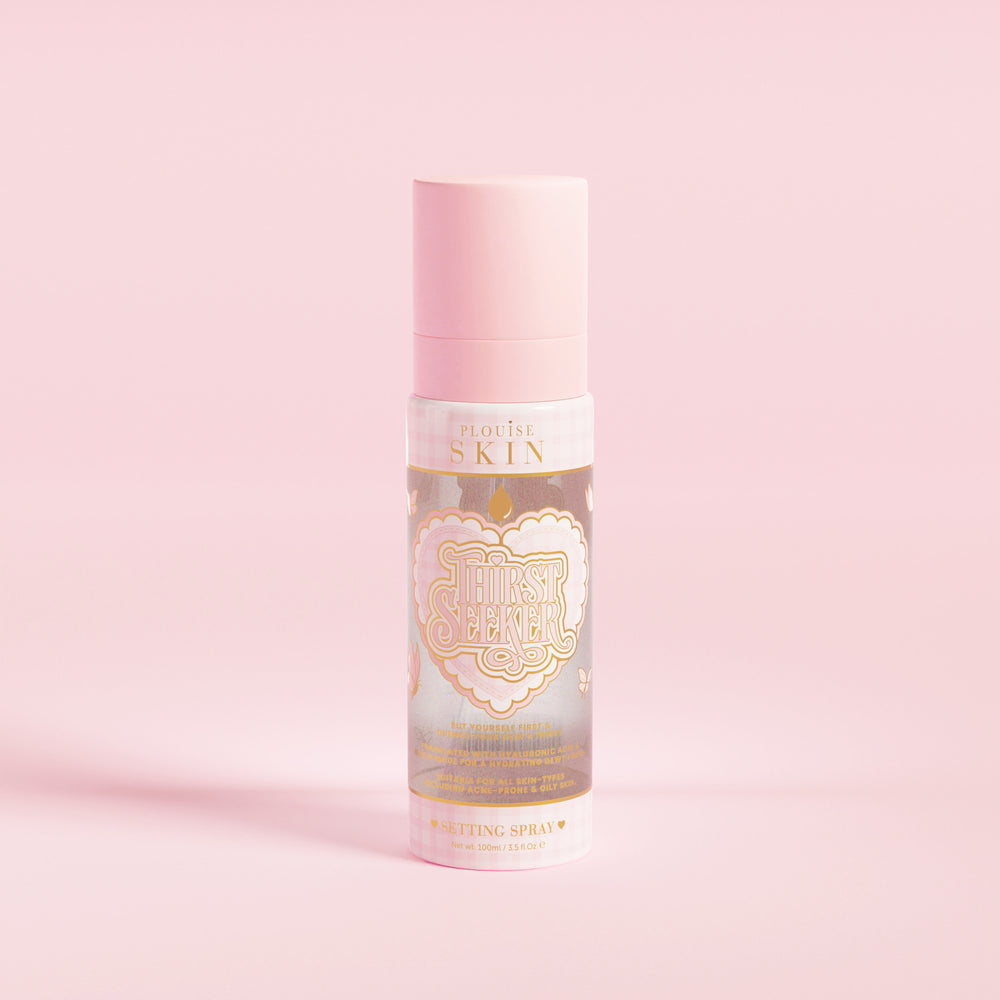 En rosa sprayflaske merket 'P.Louise SKIN' med en skildring av et hjerte og noen blomsterelementer, som inneholder en fuktighetsgivende settingspray.