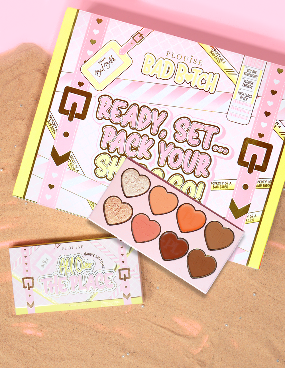 Emballage et produit de la palette pour le visage P.Louise All Over The Place présentés avec des nuances en forme de cœur de différentes couleurs sur un lit de sable.