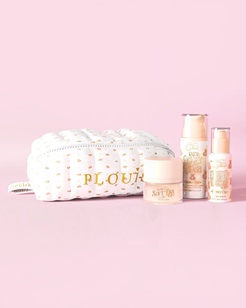 صورة لمجموعة P.Louise The Softest Touch للعناية بالبشرة مع مكياج تيدي مطبوع صغير وحقيبة للعناية بالبشرة تضم 3 منتجات للعناية بالبشرة على خلفية وردية