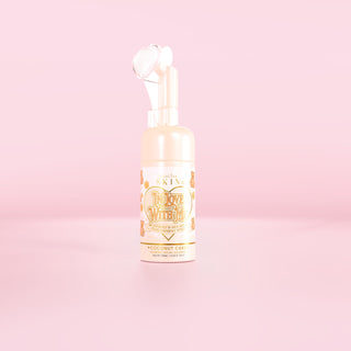 粉红色背景下的 P.Louise In Love With Me 泡沫洗面奶瓶，带有椰子蛋糕香味