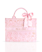 A pink tote bag with a satin bow on the handle, featuring a patterned design and the name 'PLOUISE' printed on the front, set against a clean white background.