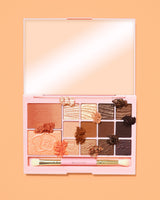 Un'immagine della palette di trucchi P. Louise Breakfast Bites All In One in tonalità calde e neutre Toasty & Tempting su sfondo arancione