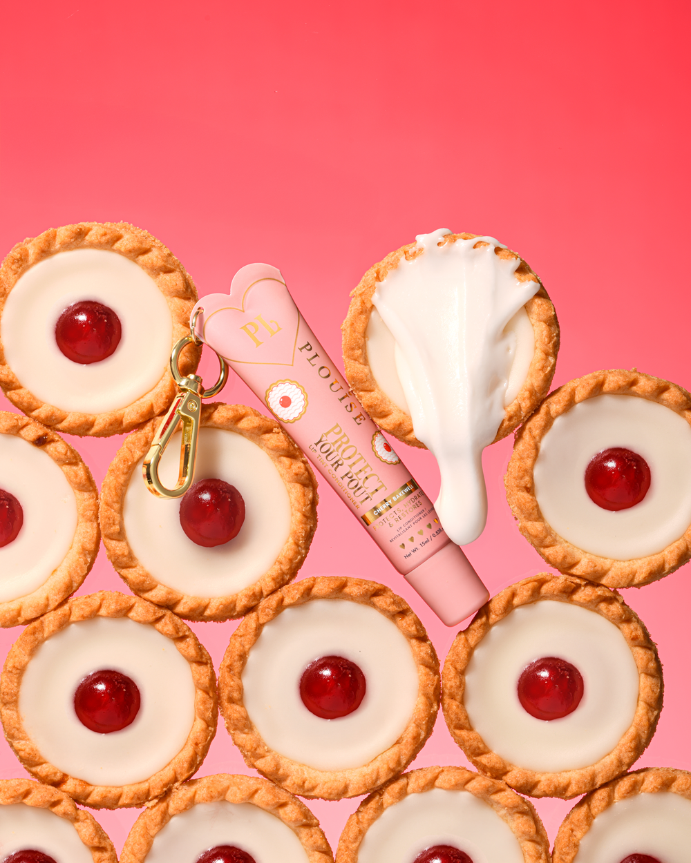 Pink kirsebær mandel duftende tonet beskyt din trutmund læbebalsam med guldklemme placeret mellem kirsebær bakewell desserter