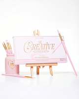 En sluten rosa P.Louise Creative Comeback XXXL Rainbow Eyeshadow Palette placerad på ett konststafli omgivet av sminkborstar