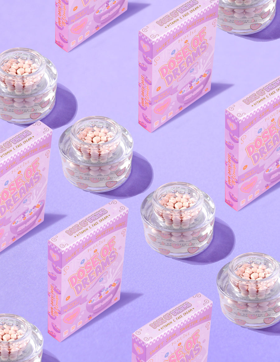 Recipientes transparentes de creme facial P.Louise DOse of Dreams Viatmin C Capsule com cápsula rosa cercada por caixas de cereal rosa em um fundo roxo