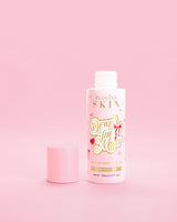 Rosa flaske P.Louise Dewin The MOst Double Layer Toner med rød sløyfedesign mot en rosa bakgrunn 
