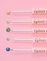 5 P.Louise Glisten To Your Heart glitter eyeliners met een druppel van het product aan het uiteinde tegen een roze achtergrond