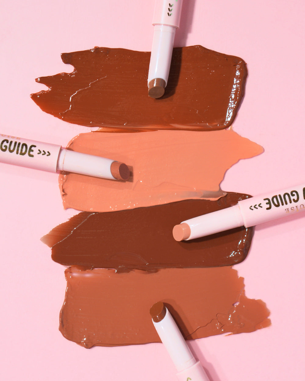 Stalen van de P.Louise Glow Guide Glossy Lipstick Balms op een roze achtergrond