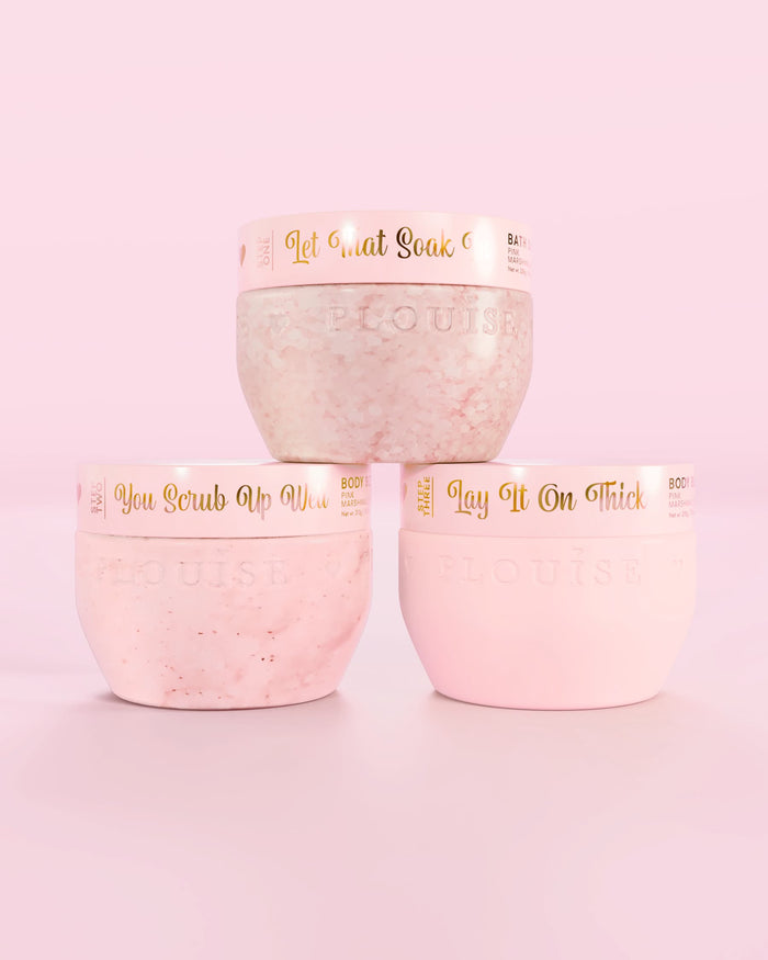 บรรจุภัณฑ์สีชมพูของ P.Louise Hop Into Self-Care Pink Marshmallow สามขวดประกอบด้วยเกลืออาบน้ำ สครับขัดผิว และบอดี้บัตเตอร์ พร้อมข้อความสีทองบนพื้นหลังสีชมพู