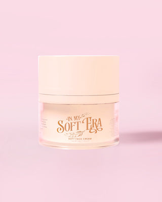 Small cream jar of P.Louise In My Soft Era soft face cream with a coconut cake scent against a pink background