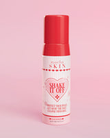 Een pompflesje P.Louise Shake It Off Foaming Face Cleanser tegen een roze achtergrond, met productinformatie en branding zichtbaar op de fles.