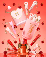 Pink XL Protect Your Pout Gavesæt, der er åbnet omgivet af kirsebær og pink og rød læbebalsam på en pink baggrund