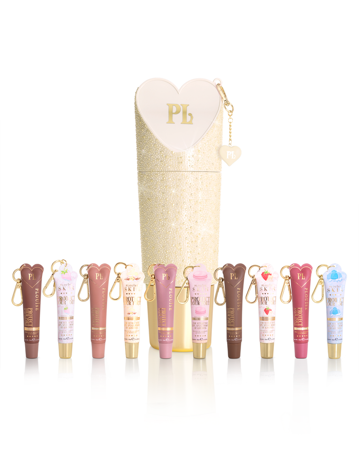A set of P.Louise protect your pout lip conditioner tubes in assorted shades arranged in front of a tall glittery cream-coloured cylindrical case with a heart-shaped zipper pull. Each tube has a small gold keychain attached.