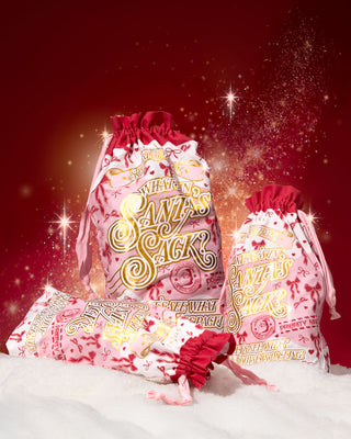 Two 'Santa's Sack' mystery bundle bags with a decorative festive design on each surrounded by snow on a red background