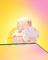 Drie containers P. Louise 'Lift It On Thick' mango body butter op een gradiënt gele en roze achtergrond