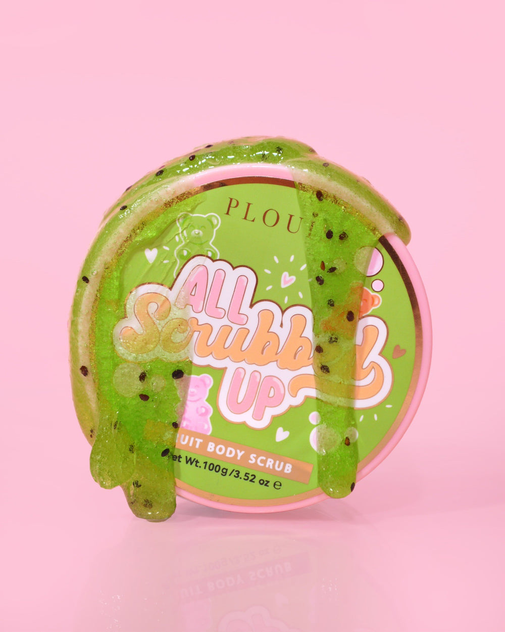 Een potje P.Louise All Scrubbed Up Body Scrub met het label 'Candy Bears' op een roze achtergrond, waarbij het product verschijnt als een groene gel