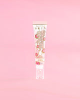 Tube P. Louise Dose Of Dreams Vitamin C Brightening Eye Cream op een roze achtergrond