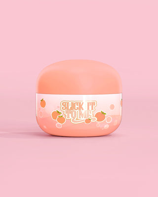 Jar of P. Louise Slick It To Me Peach Melting Body Balm with pink background