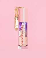 P. Louise Soak Me Lippenöl mit buntem Schichtöl in einer rosa Tube mit goldenem Verschluss auf rosa Hintergrund