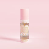 En rosa sprayflaske merket 'P.Louise SKIN' med en skildring av et hjerte og noen blomsterelementer, som inneholder en fuktighetsgivende settingspray.