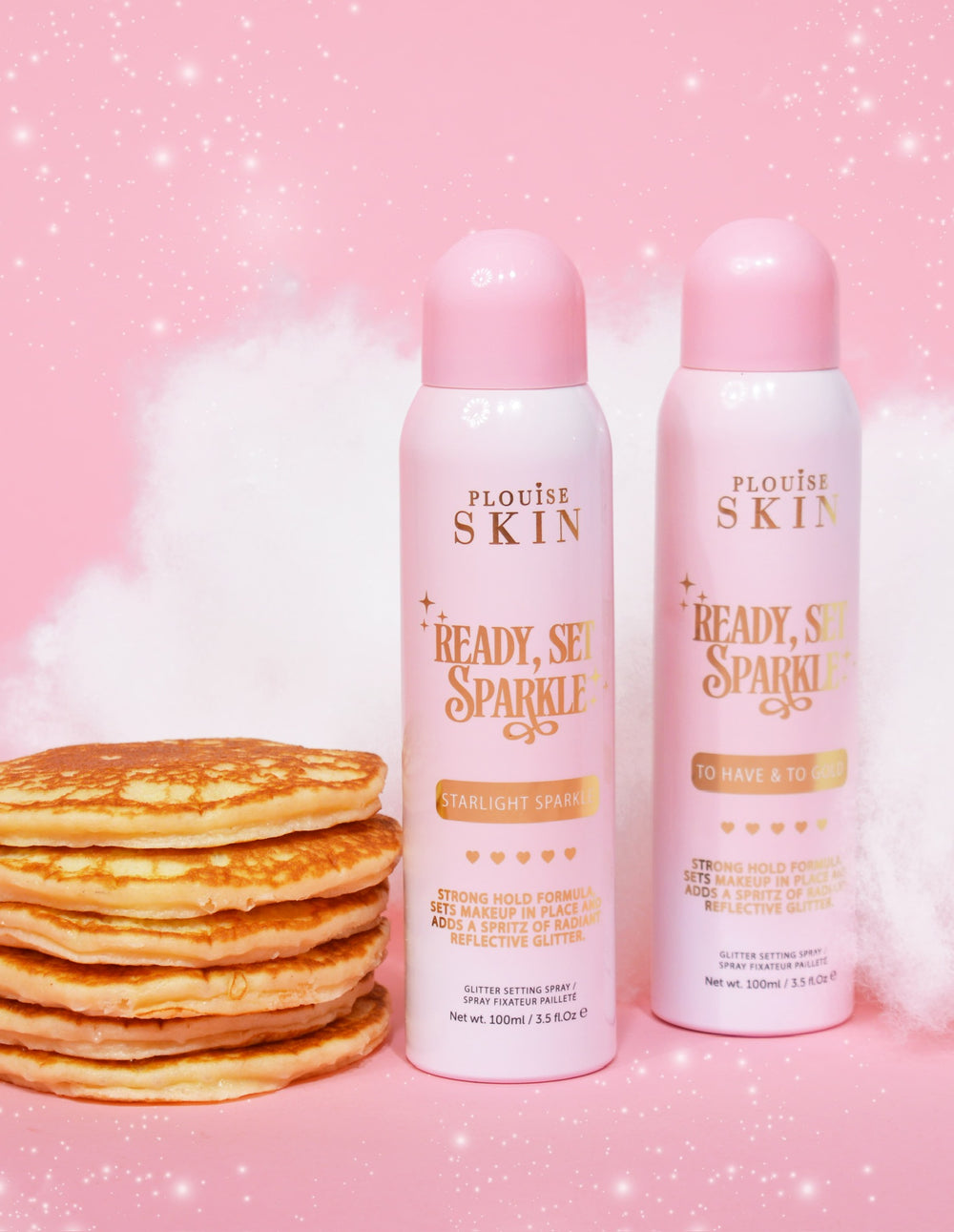 Dwie puszki aerozolowe P. Louise Ready Set Sparkle Glitter Setting Spray ze stosem naleśników i różowym tłem z błyskotkami