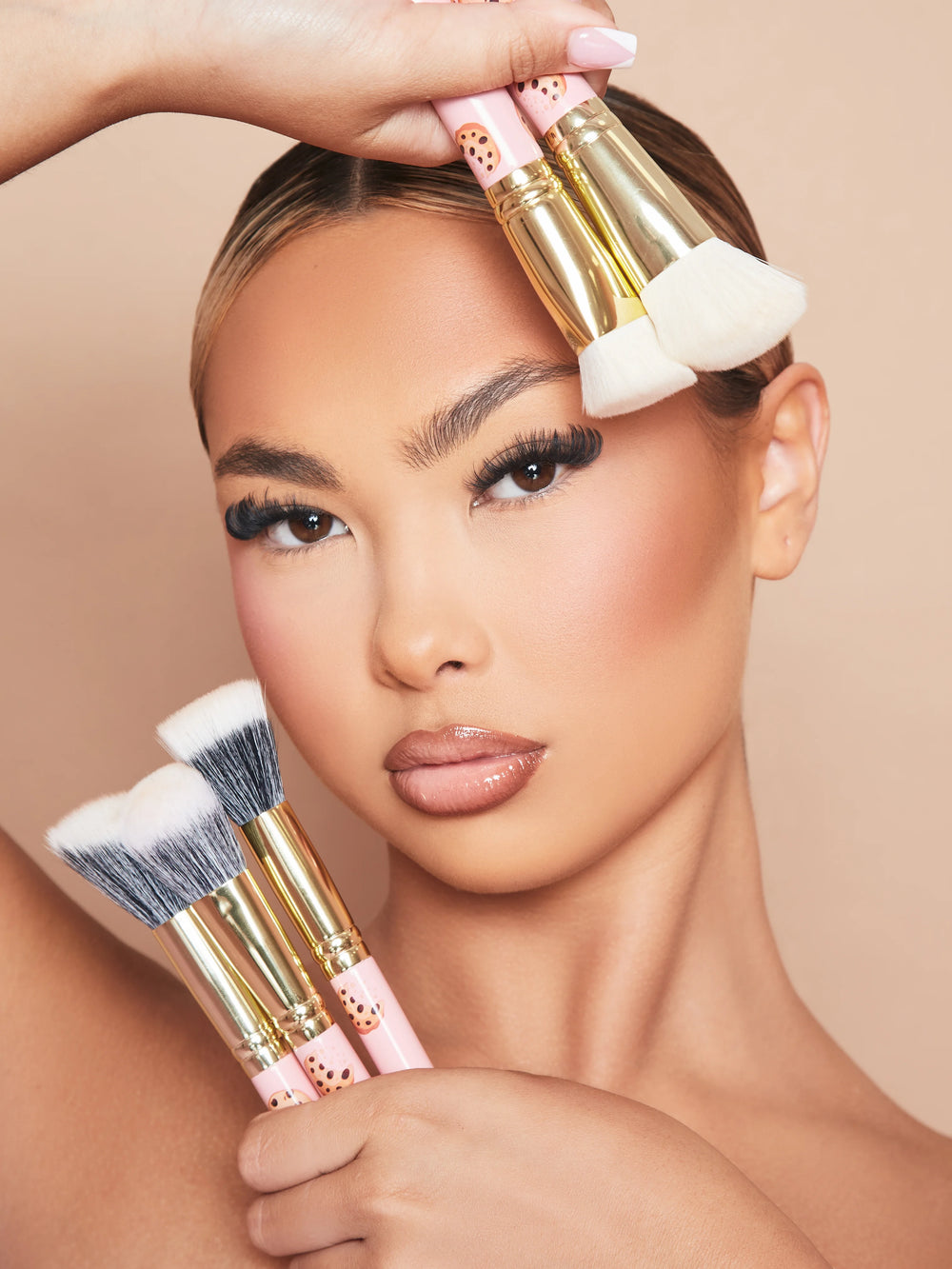 Image d'une femme mannequin maquillée tenant le lot de 5 pinceaux de maquillage P.Louise Spoiled For Choice contre son visage.