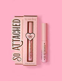 P.Louise So Attached Lash Glue productverpakking en de lijmtube zelf, geplaatst tegen een roze achtergrond.