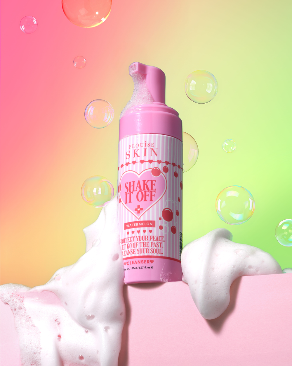 Roze schuimende fles P.Louise Shake It Off Face Cleanserv met hartontwerp op een kleurrijke achtergrond met bubbels