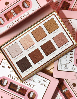 The P.Louise Love Tapes Beneath The Sheets Makeup Palette containing 8 velvety matte shades of eyeshadow with text labels for each shade, presented in a rose gold packaging with intricate designs.